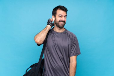 Mavi arka planda sakallı genç bir sporcunun şüpheleri var.