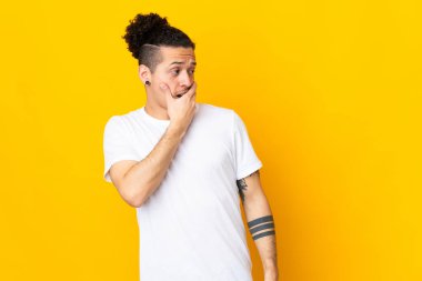 İzole edilmiş arka planda beyaz bir adam yan tarafa bakarken sürpriz jest yapıyor.