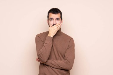 İzole edilmiş arka plandaki adam elleriyle ağzını kapatıyor.