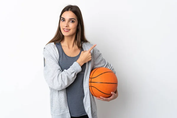 Молодая Женщина Играющая Баскетбол Изолированы Белом Фоне Указывая Сторону Представить — стоковое фото