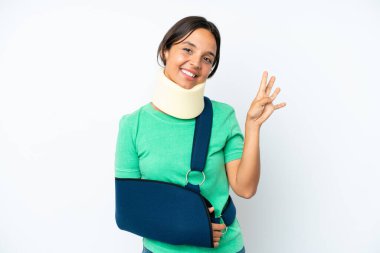 Boynunda boyunluk ve askısı olan genç İspanyol kadın beyaz arka planda izole edilmiş mutlu ve parmakları olan dört kişi sayıyor.