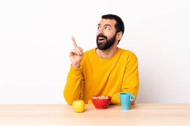 Masada kahvaltı yapan beyaz bir adam, bir fikir düşünüyor..