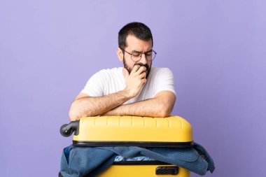 Bir bavul dolusu elbisesi olan Kafkasyalı gezgin, izole edilmiş mor arka planda kuşkuları var.