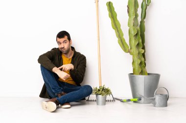 Bahçıvan içeride yerde oturuyor ve geç kalma hareketini yapıyor.