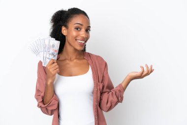 Genç Afrikalı Amerikalı bir kadın, beyaz arka planda izole edilmiş bir sürü para alıyor. Gelmesi için elini uzatıyor.