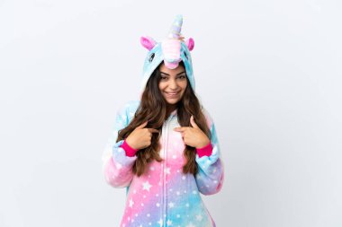 Beyaz arka planda tek boynuzlu at pijaması giyen beyaz yüzlü genç bir kadın.