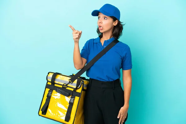 Young delivery woman with thermal backpack pointing away