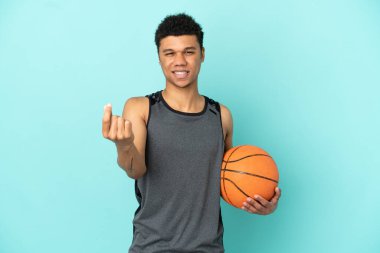 Basketball player African American man isolated on blue background making money gesture