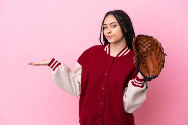 Beyzbol eldivenli genç oyuncu pembe arka planda izole edilmiş, davet etmek için ellerini yana uzatıyor.