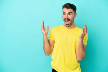 Mavi arka planda yalıtılmış beyaz bir adam. Şaşırtıcı bir yüz ifadesi var.