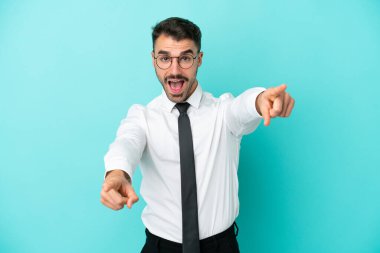 Mavi arka planda izole edilmiş beyaz bir adam sana gülümserken işaret ediyor.