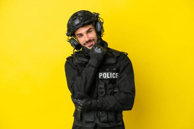 Özel Tim 'in beyaz adamı sarı arka planda izole edilmiş gülümsüyor.