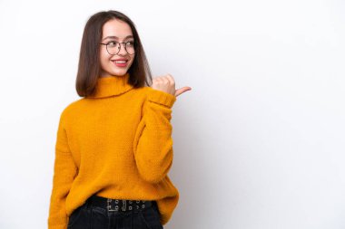 Beyaz arka planda izole edilmiş genç Ukraynalı kadın bir ürünü sunmak için kenarı işaret ediyor