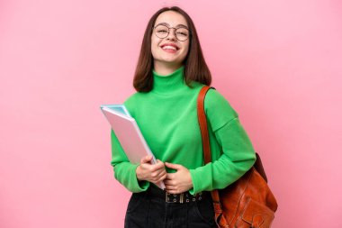 Genç öğrenci Ukraynalı kadın pembe arka planda izole edilmiş, çok gülümsüyor.