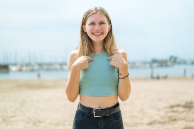 Yüzünde sürpriz bir ifade olan sarışın genç bir kadın.