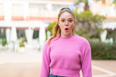 Genç ve güzel bir kız gözlüklü ve şaşırmış bir ifadeyle