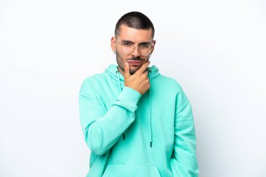 Beyaz arka planda soyutlanmış genç beyaz bir adamın şüpheleri var.