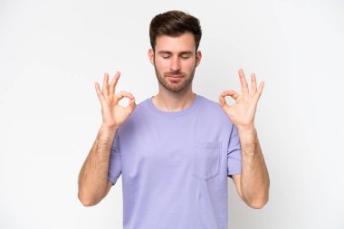 Beyaz arka planda Zen pozisyonunda beyaz tenli genç bir adam