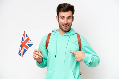 Beyaz arka planda şaşırtıcı bir yüz ifadesiyle izole edilmiş bir Birleşik Krallık bayrağı tutan beyaz bir öğrenci.