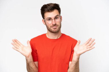 Beyaz arka planda gözlüklü ve şüpheleri olan beyaz tenli genç bir adam.