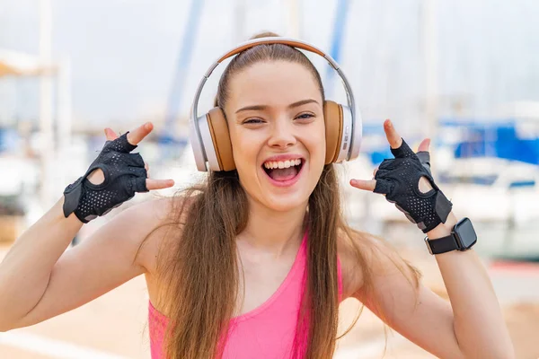 Молодая Красивая Спортивная Девушка Открытом Воздухе Слушает Музыку Делая Рок — стоковое фото