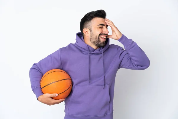 Człowiek Gra Koszykówkę Nad Odizolowaną Białą Ścianą Uśmiechając Się — Zdjęcie stockowe