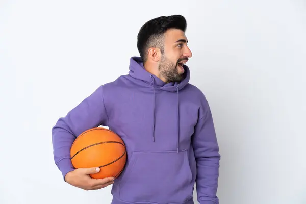 Człowiek Gra Koszykówkę Nad Odizolowaną Białą Ścianą Śmiejąc Się Pozycji — Zdjęcie stockowe