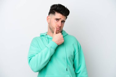 Beyaz arka planda soyutlanmış genç beyaz bir adamın şüpheleri var.