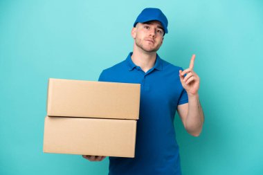 Teslimat yapan beyaz adam mavi arka planda izole edildi.