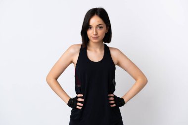 Beyaz arka planda izole genç beyaz kadın kolları kalçasında poz