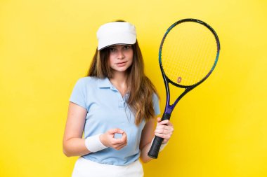 Young caucasian woman isolated on yellow background playing tennis