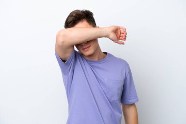 Genç ve yakışıklı Brezilyalı bir adam beyaz arka planda izole edilmiş gözleri elleriyle örtüyor.