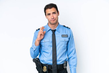 Beyaz arka planda izole edilmiş genç bir polis memuru parmaklarını çapraz yapıp en iyisini diliyor.