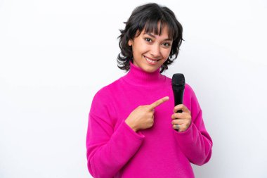 Young Argentinian singer woman isolated on white background pointing to the side to present a product