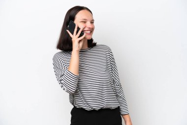 Beyaz arka planda izole edilmiş genç beyaz kadın cep telefonuyla sohbet ediyor.