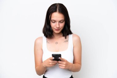 Beyaz arka planda cep telefonu kullanan beyaz tenli genç kadın.