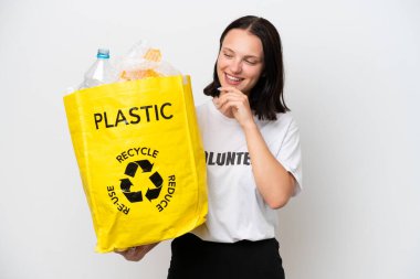 Beyaz arka planda izole edilmiş ve gülümseyen plastik şişelerle dolu bir çanta taşıyan beyaz bir kadın.