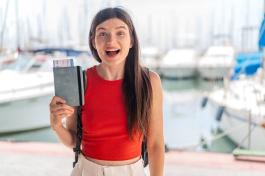 Genç, güzel, Ukraynalı bir kadın elinde pasaportuyla dışarıda şaşkınlık ve şok olmuş bir yüz ifadesiyle bekliyor.