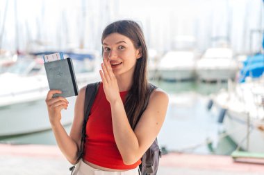 Genç, güzel, Ukraynalı bir kadın elinde pasaportuyla dışarıda şaşkınlık ve şok olmuş bir yüz ifadesiyle bekliyor.