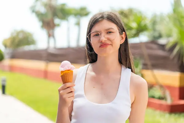 年轻而漂亮的乌克兰女人 在户外带着玉米粒冰淇淋 脸上带着忧郁的表情 — 图库照片