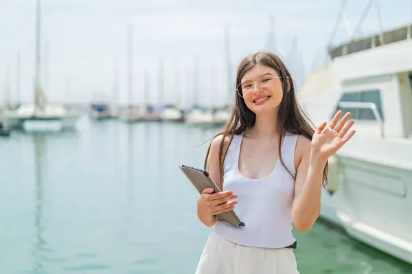 Young Pretty Ukrainian Woman Holding Tablet Outdoors Saluting Hand Happy — Stock Photo, Image
