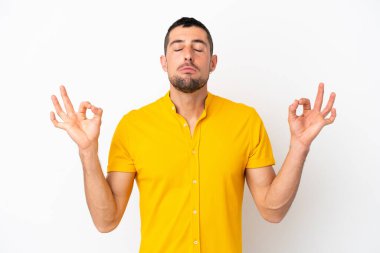 Zen pozisyonunda beyaz arka planda izole edilmiş yakışıklı beyaz bir adam.