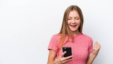 Young Russian woman isolated on white background with phone in victory position
