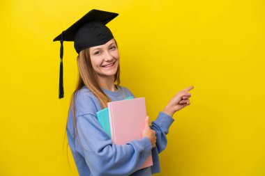 Sarı arka planda izole edilmiş genç bir Rus kadın parmak işareti yapıyor.