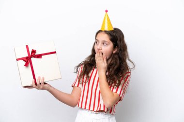 Doğum günü pastası ile izole edilmiş bir arka planı olan küçük bir kız şaşırmış ve şok olmuş bir yüz ifadesi var.