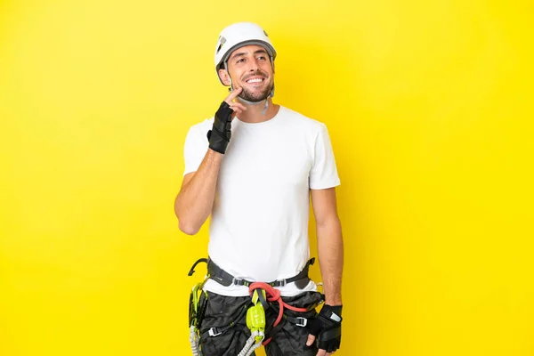 Young Rock Climber Man Isolated Yellow Background Thinking Idea While — Stock Photo, Image