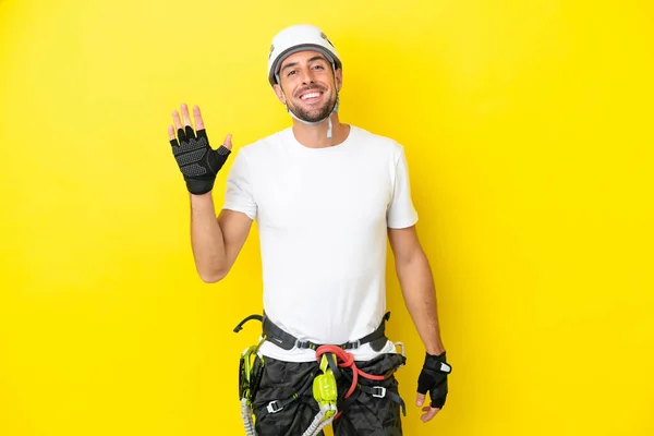 Young Rock Climber Man Isolated Yellow Background Saluting Hand Happy — Stock Photo, Image