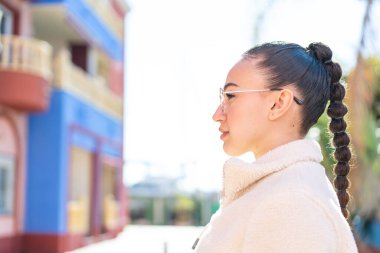 Dışarıdaki Faslı genç kız gözlüklü.