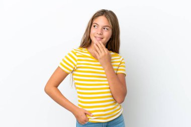 Beyaz arka planda izole edilmiş küçük beyaz kız gülümserken yukarı bakıyor.