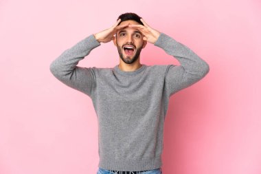 Young caucasian man isolated on pink background with surprise expression